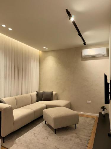 sala de estar con sofá grande y ventilador de techo en INCASSO CITY CENTER APARTMENT, en Tirana