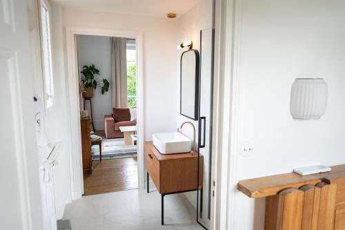 a hallway with a bathroom with a sink and a mirror at LA GRANDE MAISON LGM in Lesches