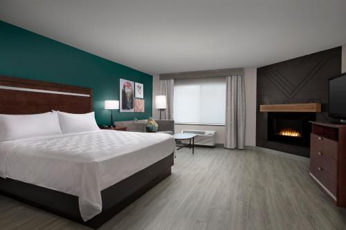 a hotel room with a bed and a fireplace at Holiday Inn & Suites Durango Downtown by IHG in Durango