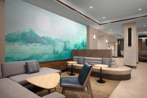 a lobby with couches and tables and a large painting at Holiday Inn & Suites Durango Downtown, an IHG Hotel in Durango