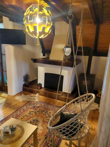 a room with a swinging chair and a fireplace at Tarski vrh in Bajina Bašta