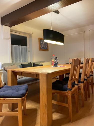uma sala de jantar com uma mesa de madeira e cadeiras em Lindenhof - Zentral zwischen MR und GI em Niederweimar