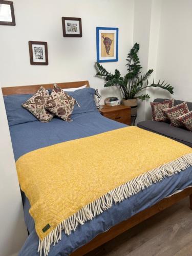 a bedroom with a blue bed with a yellow blanket at 2 bed/2 bath luxury flat with city view! in London