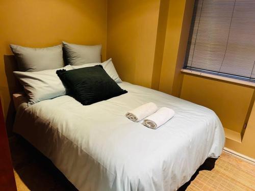 a bedroom with a large bed with two towels on it at 0.5 Studio Apartment at Paarl CBD in Paarl