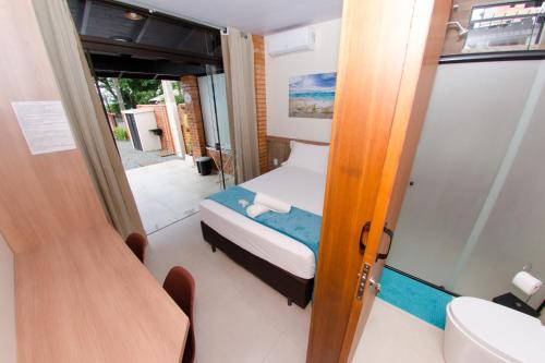 Kleines Zimmer mit einem Bett und einem Bad. in der Unterkunft Pousada Viva praia 30 metros da Praia in Penha