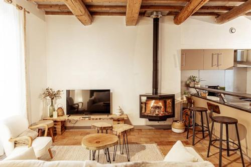 a living room with a fireplace and a table at Maison de village Barbentane avec spa in Barbentane