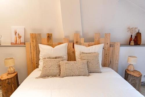 a bedroom with a bed with a wooden headboard and pillows at Maison de village Barbentane avec spa in Barbentane