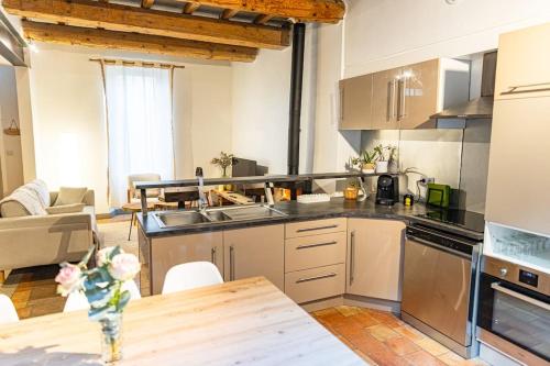 a kitchen with a wooden table in a room at Maison de village Barbentane avec spa in Barbentane