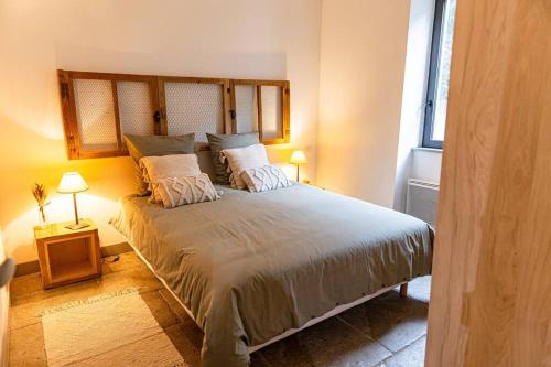 a bedroom with a large bed with two pillows at Maison de village Barbentane avec spa in Barbentane