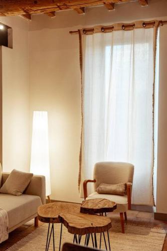 a living room with a couch and a table at Maison de village Barbentane avec spa in Barbentane