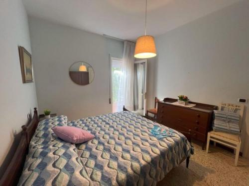 1 dormitorio con 1 cama, vestidor y ventana en Elegant villa in a quiet area with garden en Bibione