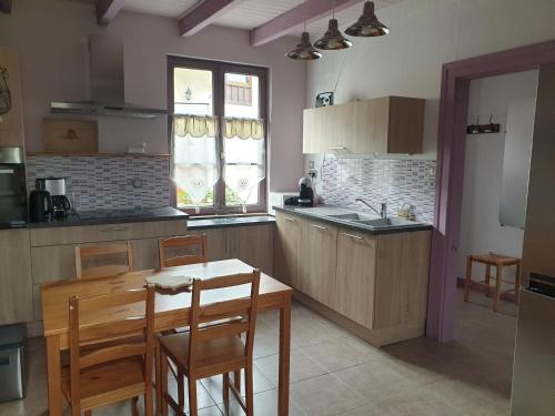 a kitchen with a table and chairs and a kitchen with a sink at Gîte 4 étoiles La Belle Eau Calme in Futeau