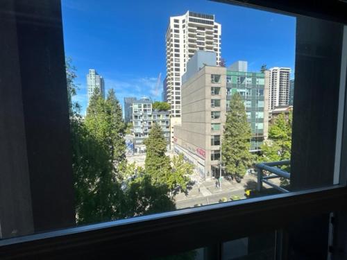 a window with a view of a city with tall buildings at Quest Travels in Seattle
