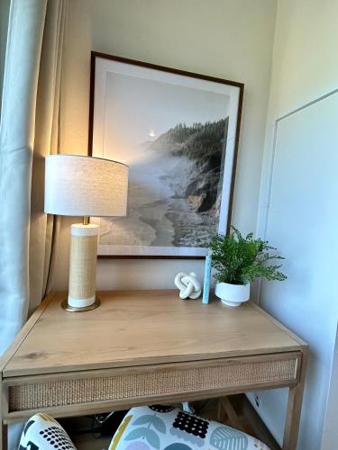 a table with a lamp and a picture on the wall at Quest Travels in Seattle