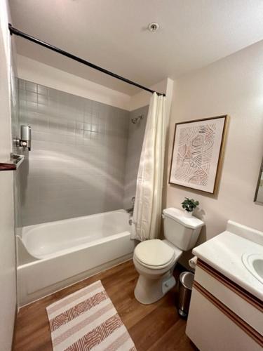 a bathroom with a toilet and a tub and a sink at Quest Travels in Seattle