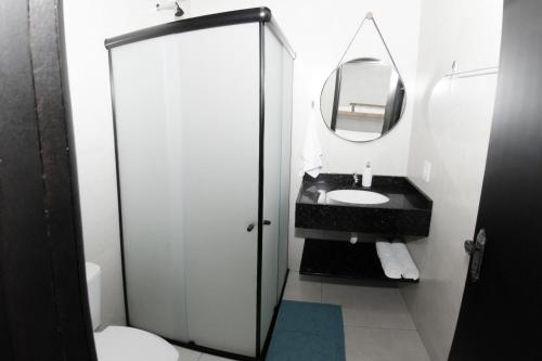 ein Bad mit einem Waschbecken und einem Spiegel in der Unterkunft Pousada Viva praia 30 metros da Praia in Penha