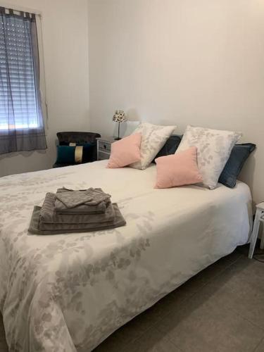 un lit avec des oreillers et une couverture dessus dans l'établissement Maison confortable et agréable, à Saint-André-de-Cubzac