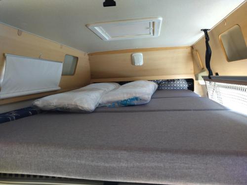 เตียงในห้องที่ alquiler autocaravana Camper