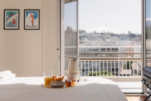 a breakfast tray with orange juice and donuts on a bed at Patras Skyline Suite in Patra
