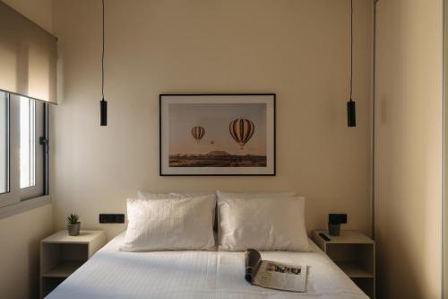 Patras Skyline Suite في باترا: غرفة نوم مع سرير مع اثنين من بالونات الهواء الساخن