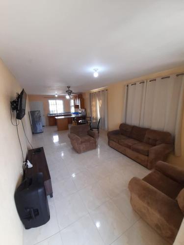 a large living room with couches and a television at Seville Meadows 3 - Johns Road Spanish Town in Spanish Town