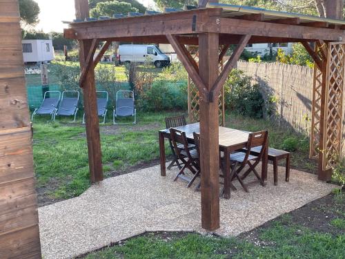 - un kiosque en bois avec une table et des chaises dans l'établissement Bungalow moderne proche étang et mer, à Le Castellas