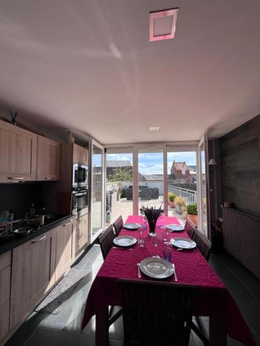 - une cuisine avec une table et une nappe rouge dans l'établissement La Terrasse, au Crotoy