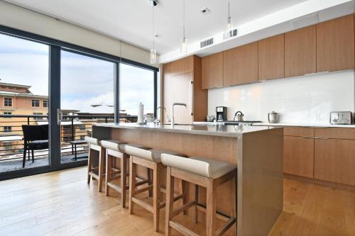 a kitchen with a bar with a view of a balcony at Lift Park City Condominiums in Park City