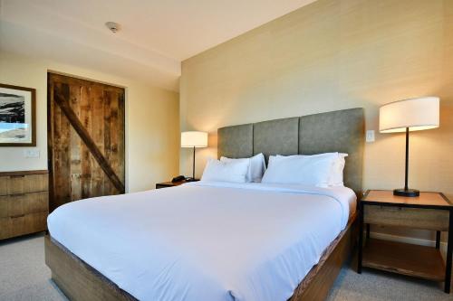 a bedroom with a large bed and a wooden door at Lift Park City Condominiums in Park City