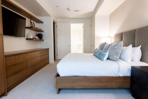 a bedroom with a large bed and a flat screen tv at Lift Park City Condominiums in Park City