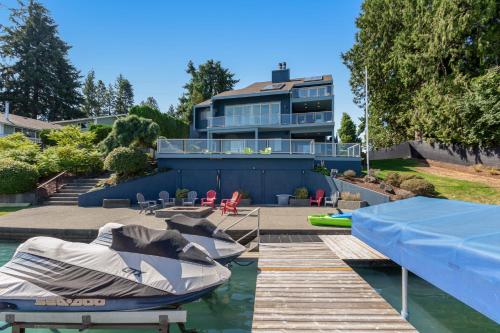 a house with a boat in the water at Zen Oasis On Lake Tapps in Sumner