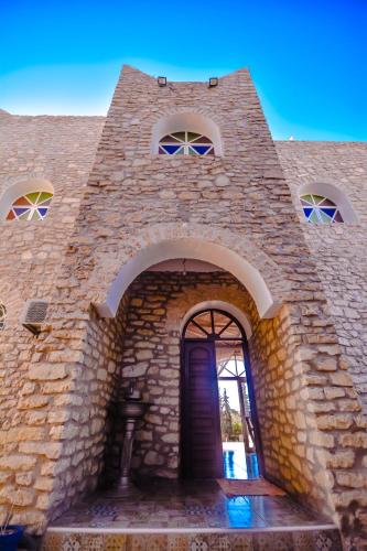 an entrance to a brick building with a blue door at Villa jamal essaouira in Essaouira
