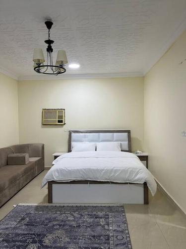 1 dormitorio con 1 cama grande y 1 sofá en Studio - غرفة استوديو بالدور 1, en Al Rass