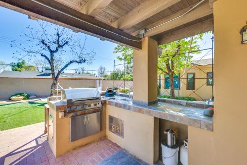 an outdoor kitchen with a grill on a patio at Spacious Uptown Phoenix Home with Pool and Yard Games! in Phoenix