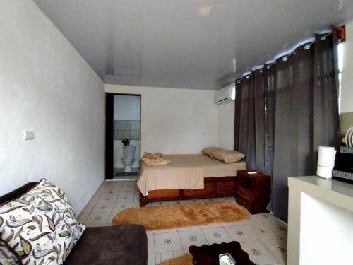 プエルト・ヒメネスにあるAnluka Estudioのベッド1台とソファが備わる小さな客室です。