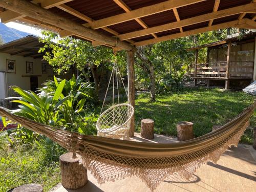 eine Hängematte auf einer Terrasse unter einer Pergola in der Unterkunft Terra Encantada in Maranura