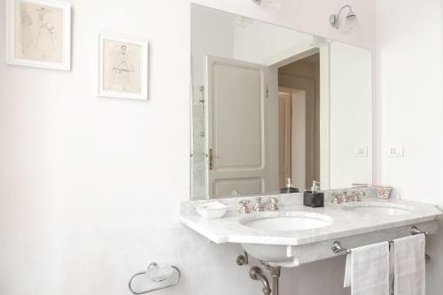 a white bathroom with a sink and a mirror at Villa Monacelli in Fano