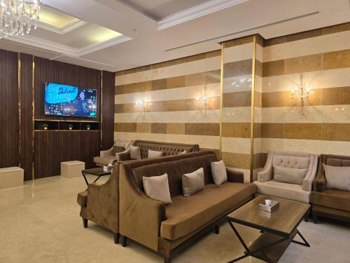 un soggiorno con divani e TV a parete di سحابة الأحلام - Dream Cloud Hotel a Gedda