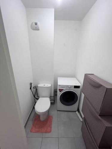 une petite salle de bains avec toilettes et lave-linge. dans l'établissement Appartement 5 personnes, à Pierrefitte-sur-Seine