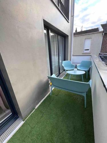 un balcon avec une table et des chaises sur un immeuble dans l'établissement Appartement 5 personnes, à Pierrefitte-sur-Seine