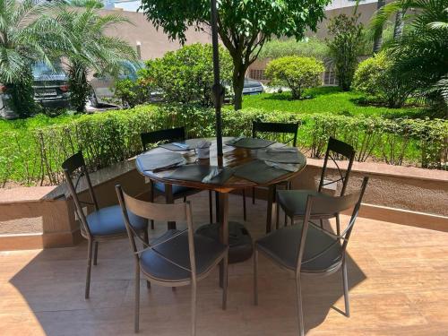 a table with chairs and an umbrella on a patio at FLAT Ibirapuera Jardins ótima localização com garagem inclusa! in Sao Paulo