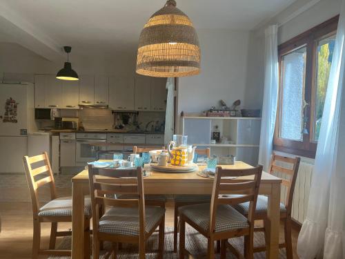 a dining room table with chairs and a chandelier at Casa Marilu Sallent in Sallent de Gállego