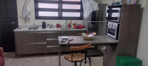 una pequeña cocina con mesa y encimera en Flat charmoso na praia de Juquehy, en São Sebastião