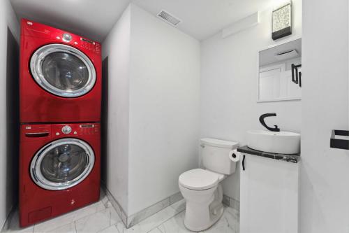 a red washer and dryer in a bathroom with a toilet at Modern 3BR Suites in Ottawa