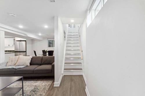 a white staircase in a living room with a couch at Modern 3BR Suites in Ottawa