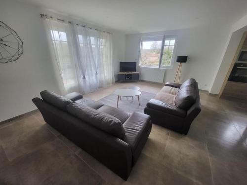 a living room with a couch and a table at Pavillon bord de nature in Courcelles-sur-Blaise