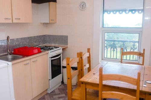 a kitchen with a stove and a table with chairs at THE CHADWICK in Skegness
