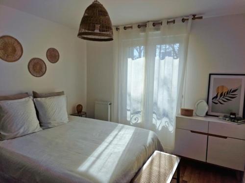 ein Schlafzimmer mit einem großen weißen Bett und einem Fenster in der Unterkunft Cozy apartment near Paris in Clamart