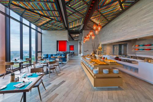 Un restaurante con mesas, sillas y ventanas. en Holiday Inn Resort Vana Nava Hua Hin, an IHG Hotel, en Hua Hin