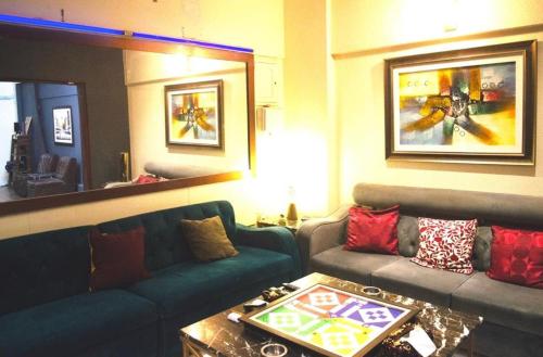sala de estar con sofá y mesa en Cottage Hotel, en Karachi